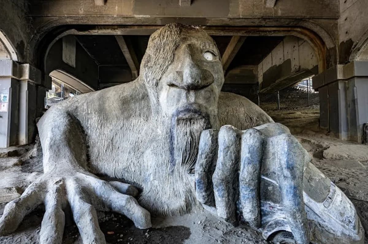 Fremont Troll under the Aurora Bridge clutching a real VW Beetle in its hand