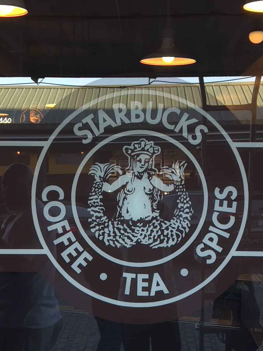 Original Starbucks siren logo etched on glass — the original Pike Place location